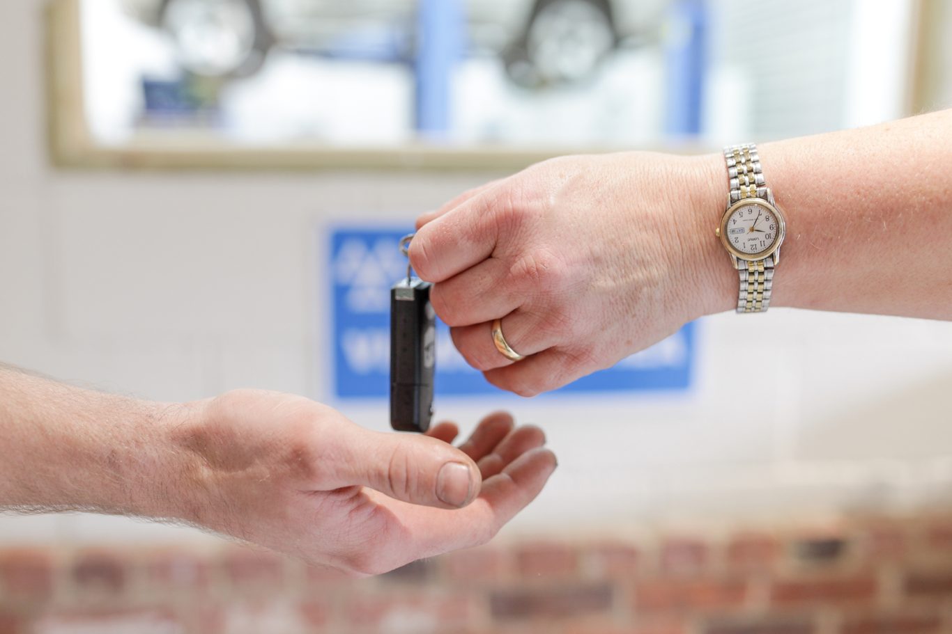 A friendly member of staff hands back car keys to a satisfied customer.