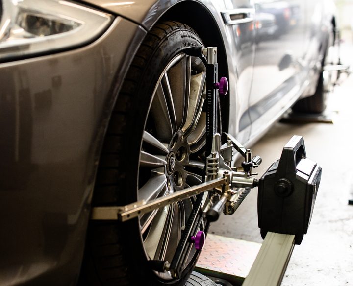 Close-up of Phipps Motors' wheel alignment equipment in use on a vehicle's front wheel